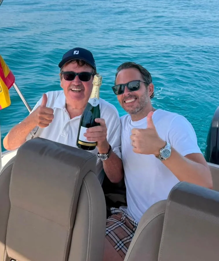Grandad and Dad on a boat, both giving a thumbs up